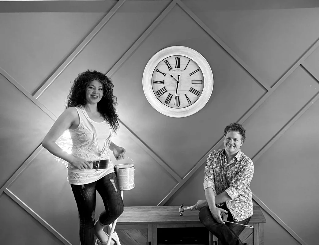 Jaimee and Leif Shires beside a geometric accent wall.