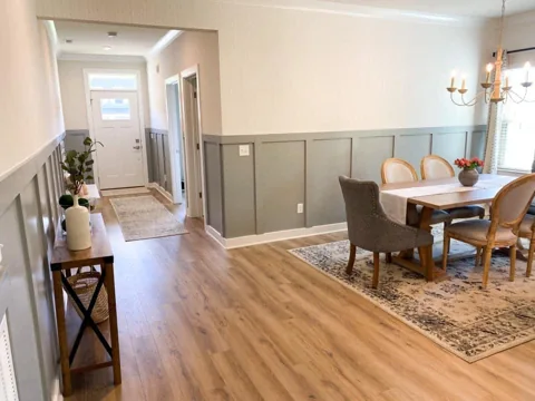 Gray lower wall panels continue from the dining area along a hallway.