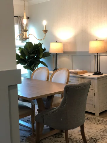 Gray lower wall panels provide a backdrop for a dining table and sideboard.