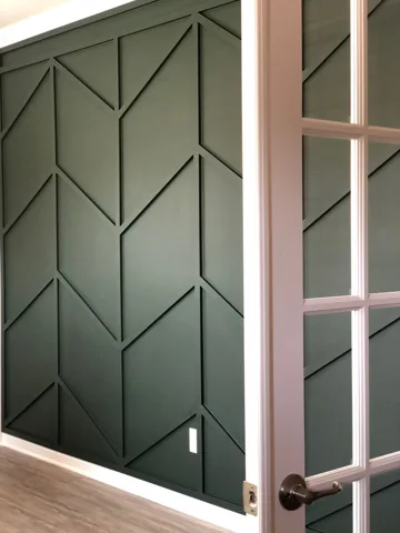 Deep green diagonal and vertical trim is visible through an office doorway.