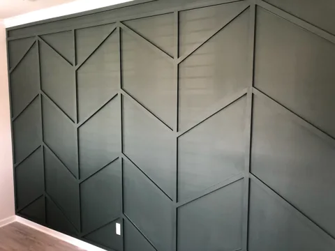 Deep green trim forms an angular pattern across an office wall.