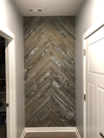 Wood boards form a chevron pattern in a narrow entry alcove.