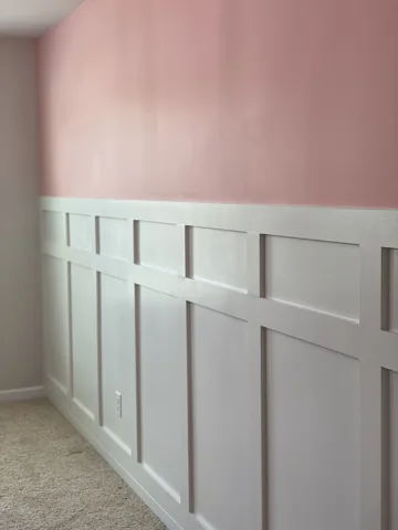White rectangular lower panels meet a soft pink upper wall.