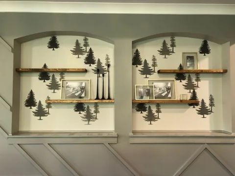 Decorative wall panels and floating wood shelves surround framed art.
