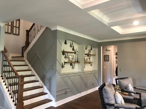 Gray decorative wall panels continue beside a staircase and living room.