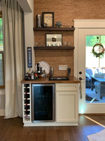 A wood-backed bar area combines open shelves with lower cabinetry.