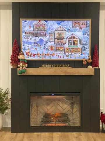 A wood mantel crosses a dark vertically paneled fireplace wall.