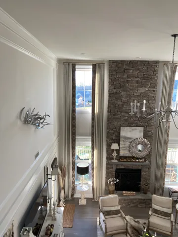 A tall white living-room wall combines fireplace detail, shelving, and vertical paneling.